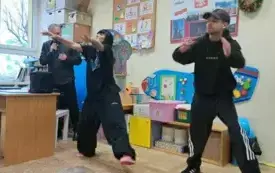 Tancerka i tancerz tańczą przed dziećmi.