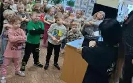 Dzieci stoją. Naśladują gesty tancerki