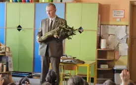 Leśnik pokazuje dzieciom pień drzewa
