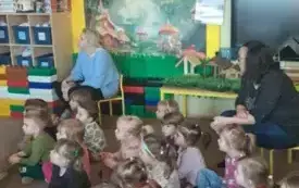 Dzieci siedza na dywanie.