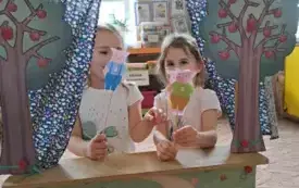 Na dywanie stoi teatrzyk. W teatrzyku są dzieci. Trzymają w rękach wykonane figurki na patyczku.