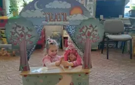 Na dywanie stoi teatrzyk. W teatrzyku są dzieci. Trzymają w rękach wykonane figurki na patyczku.