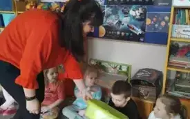 Pani pokazuje dzieciom miskę z pianką. Dzieci przyglądają się.