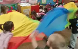 Dzieci bawią się chustą animacyjną.