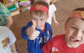 Dzieci mają  walentynkowe opaski na głowie , uśmiechają się.