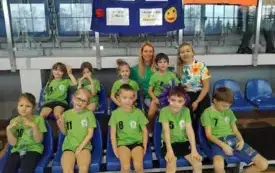 Dzieci siedzą i uśmiechają się.