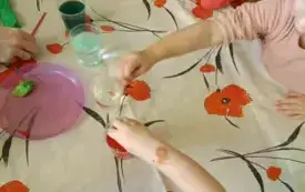 Dzieci wkładają pipety do kolorowej wody.