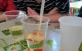 Chłopiec wkłada pipetę do wody.
