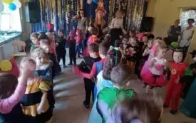 Dzieci przebrane w stroje karnawałowe tańczą.