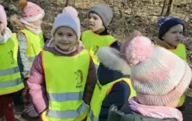 Dzieci stoją w lesie parami.