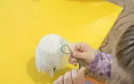 Dzieci zakładają gumki na słoiki.
