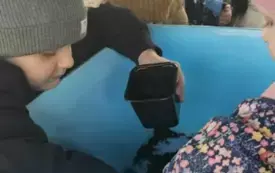 Dzieci wsypują ziemią do doniczek.