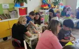Rodzice z dziećmi siedzą przy stolikach.