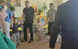 Rodzice z dziećmi stoją w kole.