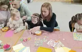 Rodzice razem z dziećmi uczestniczą w warsztatach wielkanocnych.
