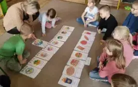 Dzieci siedzą na dywanie rozmawiają o zdrowiu.