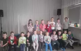 Dzieci stoją z wykonanym jajkiem wielkanocnym.