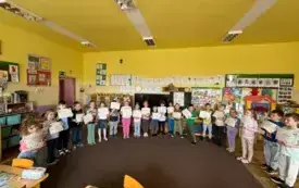 Dzieci stoją z dyplomami  ,uśmiechają się .