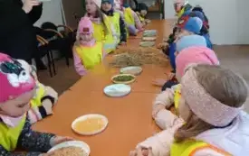 Dzieci siedzą przy stole.