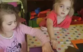 Dzieci opklejają pudełka kartonowe kolorowym papierem.