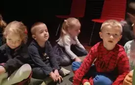 Dzieci siedzą w teatrze.