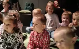 Dzieci siedzą w teatrze.