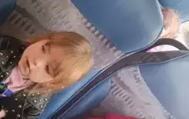 Dzieci siedzą w autokarze. Uśmiechają się do zdjęcia.