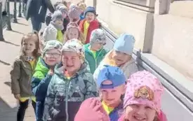 Dzieci stoją przed teatrem.