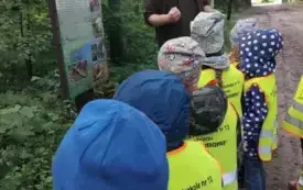 Dzieci przyglądają się tablicy edukacyjnej.