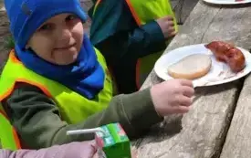 Chłopiec je kiełbaskę.