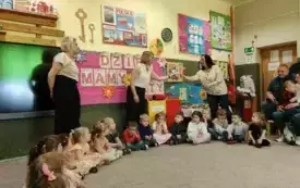 Dzieci siedzą na dywanie jeden obok drugiego