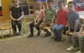 Dzieci siedzą na krzesełkach