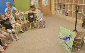 Dzieci siedzą na krzesełkach