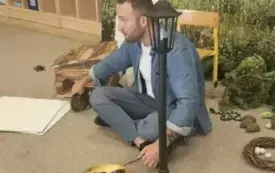 Pan siedzi na dywanie. obok niego stoją rekwizyty.