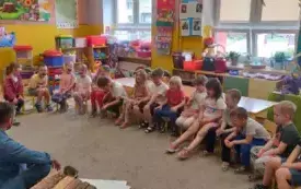 Dzieci siedzą i uśmiechają się.