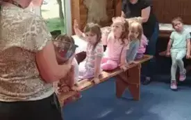 Dzieci siedzą na ławkach