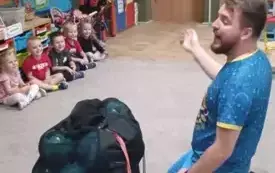 Dzieci siedzą na dywanie w siadzie skrzyżnym