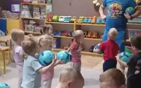 Dzieci trzymają piłki i patrzą na Pana Kangura
