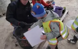Chłopiec wyjmuje z kosza kiełbase