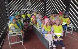 Dzieci siedzą na ławeczkach