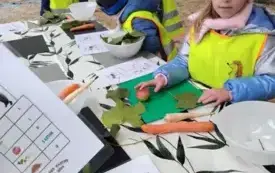 Dzieci oglądaja kartki siedząc przy stole