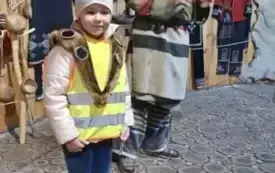 Dziecko stoi ,uśmiecha się.