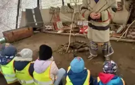 Dzieci siedzą i zapoznają się z atrybutami Indianina.