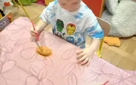 Chłopiec maluje farbami mase solną.