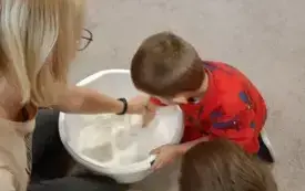 Dziecko z nauczycielką wyrabia masę solną