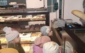 Dzieci oglądają w sklepie pieczywo.