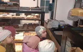 Dzieci oglądają w sklepie pieczywo.