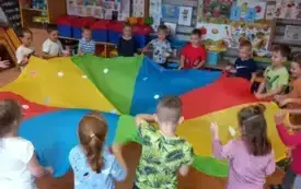Dzieci trzymaja chustę animacyjną w rękach