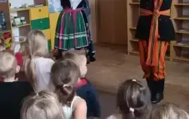 Pan z panią przebrani w stroje łowickie pokazują gesty.