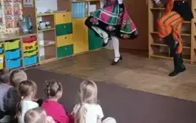 Pan z panią przebrani w stroje łowickie tańczą.